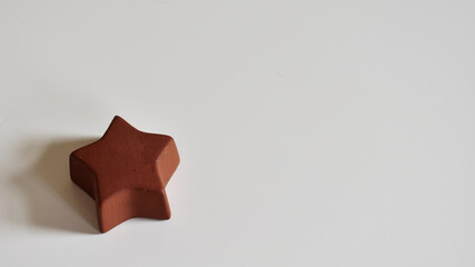 Brauner Stern aus Keramik auf weißem Hintergrund, Platz für weihnachtliche Botschaft