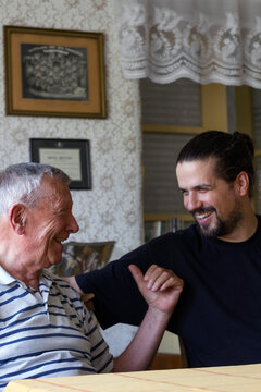 Grandpa and his adult grandson having a laugh