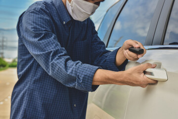 Man wearing medical mask are opening car door