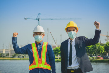 Businessman Senior Engineer wearing facemask show hand up success on site construction, Engineer and Project momager Achievement