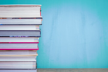 Image of many books on a wooden table and blue background.