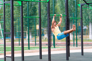 Strong barefoot young athlete practicing on bars