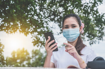 Asian women in face mask  holding phone online E-learning