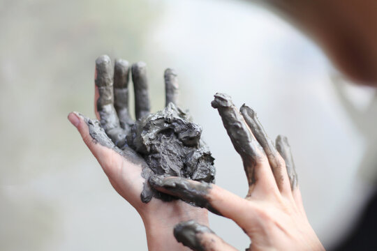 Female hands making a human face out of clay