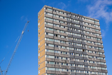 A council housing tower block at Agar Grove Estate in London and a crane