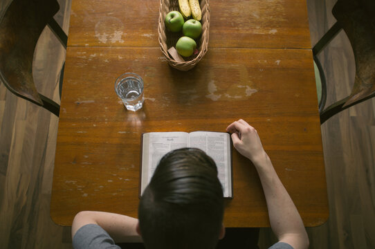 Boy reading Holy Bible on the table