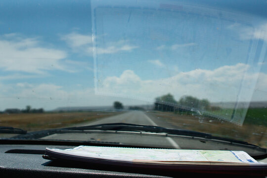 A road atlas sits on the dashboard of a pickup