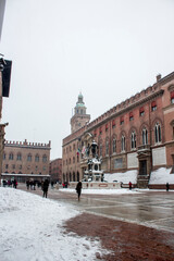 Bologna, Italy - 12 13 2019: Neputune statue from behind in close up covered by winter. Historical city hall in background. Location: Bologna, Emilia - Romagna Region ( Italy).