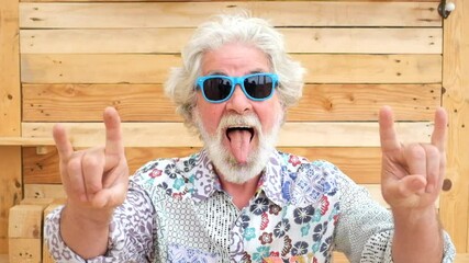 Handsome senior aged alternative diverse caucasian mature man in front of the camera in funny and nice portrait - cheerful retired people have fun and enjoy life