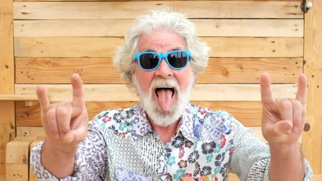 Handsome senior aged alternative diverse caucasian mature man in front of the camera in funny and nice portrait - cheerful retired people have fun and enjoy life