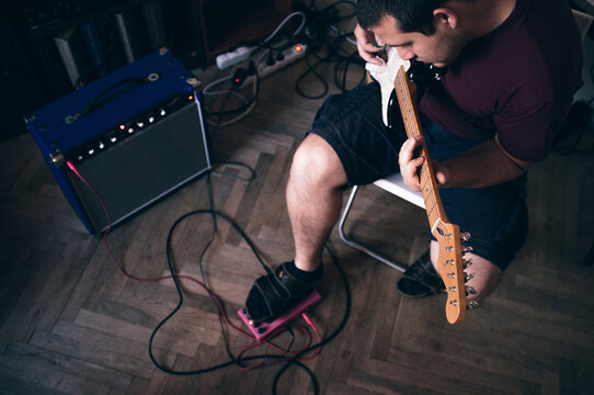 Guy playing on eletric guitar with amp