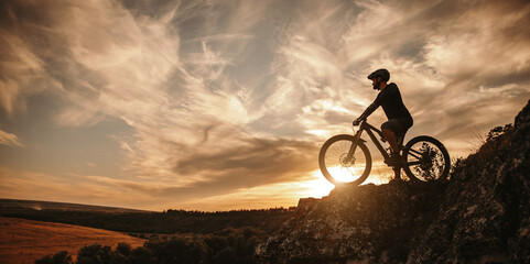 Fototapeta Man on mountain bike against sundown sky obraz