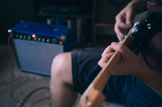 Guy playing on eletric guitar with amp