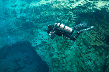 Diver's immersion in a natural funnel with clear water. The water is only 6 degrees, the...