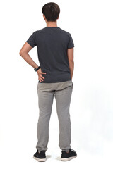 Fototapeta premium full portrait of a teenage boy dressed in sportswear on white background, back view and hand on hip