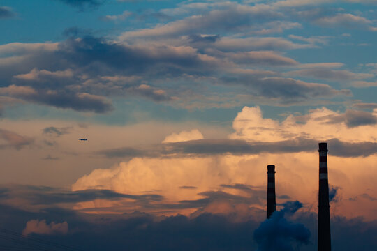 Chimney and plane at sunet