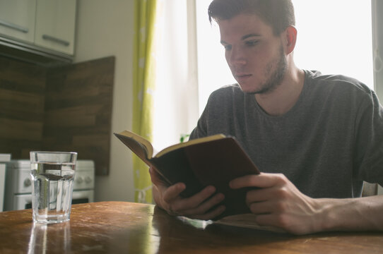 Boy reading Holy Bible on the table