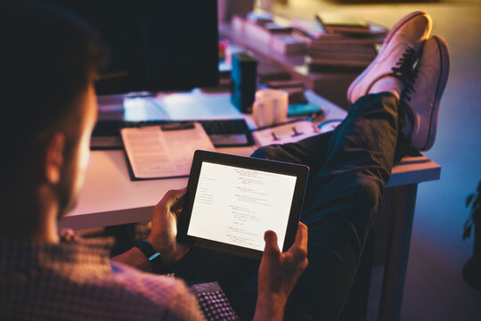 Programmer Looking at a Computer Code on a Tablet