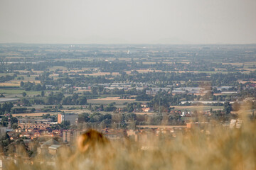 Panoramic view of Bologna from Bolognese hills. The city in background with rural fields and wheat in close up. Emilia Romagna Region, Italy