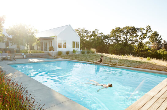 Girlfriends lounging by pool in summer