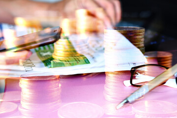 Double exposure, business working a smartphone and coins stacked background and advertising coins of finance and banking, increasing columns of gold coins on table