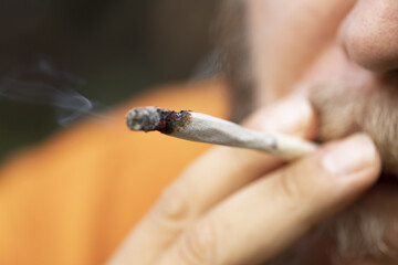 Man smokes a joint with CBD hemp