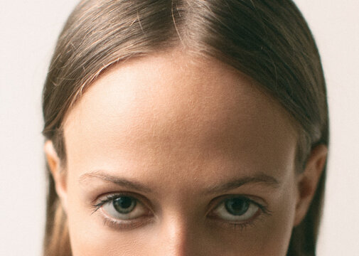 Close up on the blue eyes of a young woman. Half face.