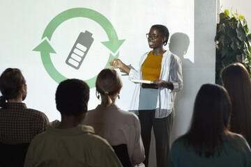 Portrait of young African-American woman giving speech on renewable energy during recycling and...