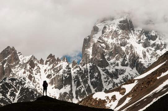Woman trekker looking out at Mount Ushba, Caucasus Mountains, Georgia.