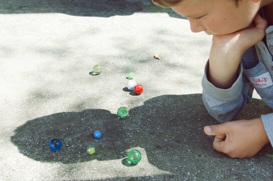 Boy playing with colorful marbles