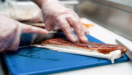 Sushi chef slicing fish