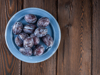 Plum fruit on a dark wooden background.