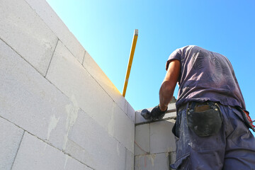 Construction worker (bricklayer) works on the construction site