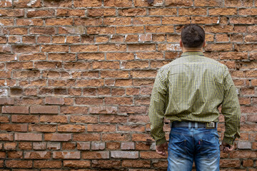 Fototapeta na wymiar Man on the background of a red brick wall.