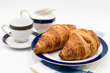 Breackfast with croissants and cup of coffee on a white background