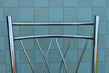 backrest of modern metal chair on vintage wallpaper background