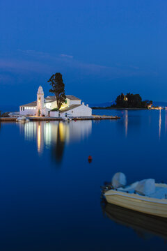 Illuminated church and island surrounded by a calm sea at night