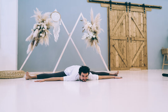 Focused Ethnic Man Doing Splits Exercise