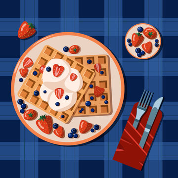Belgian Waffles With Whipped Cream, Strawberry And Blueberry On The Blue Check Tablecloth With The Set Of Cutlery