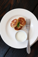 Cheese pancake with sause on the dark rustic wood table. Top view