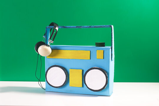 Diy retro ghetto blaster made by cardboard in front a green background.