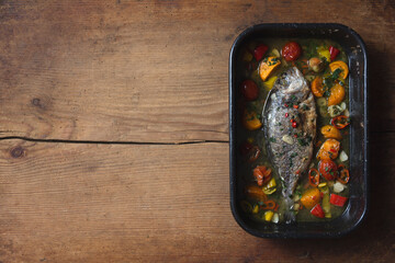 Food: fish cooked in wine with cherry tomatoes and pepper. Italian recipe.