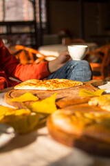 
The guy sits in a cafe with a cup of tea and khachapuri
