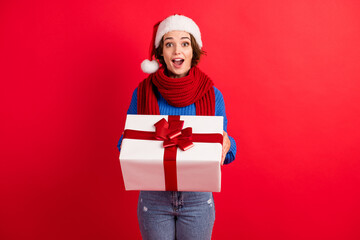 Photo astonished girl in santa claus headwear get receive gift box christmas midnight party scream wow omg wear knitted pullover denim jeans isolated bright shine color background