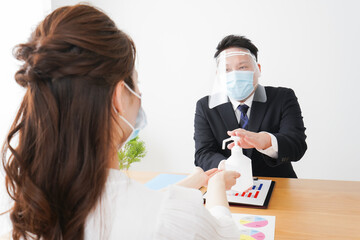 感染症予防のために手の消毒をするビジネスパーソン