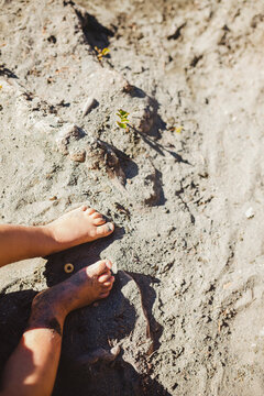 Cute toddler feet and toes in sand in summer