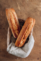 French baguettes in wicker basket with linen napkin