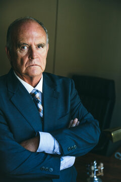 Senior businessman portrait on his office wearing a suit