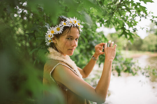 A young free-spirited girl gazes into the camera before photographing the beautiful moment herself