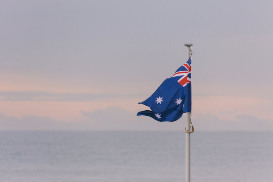 Australia flag with the sea on the background at sunset